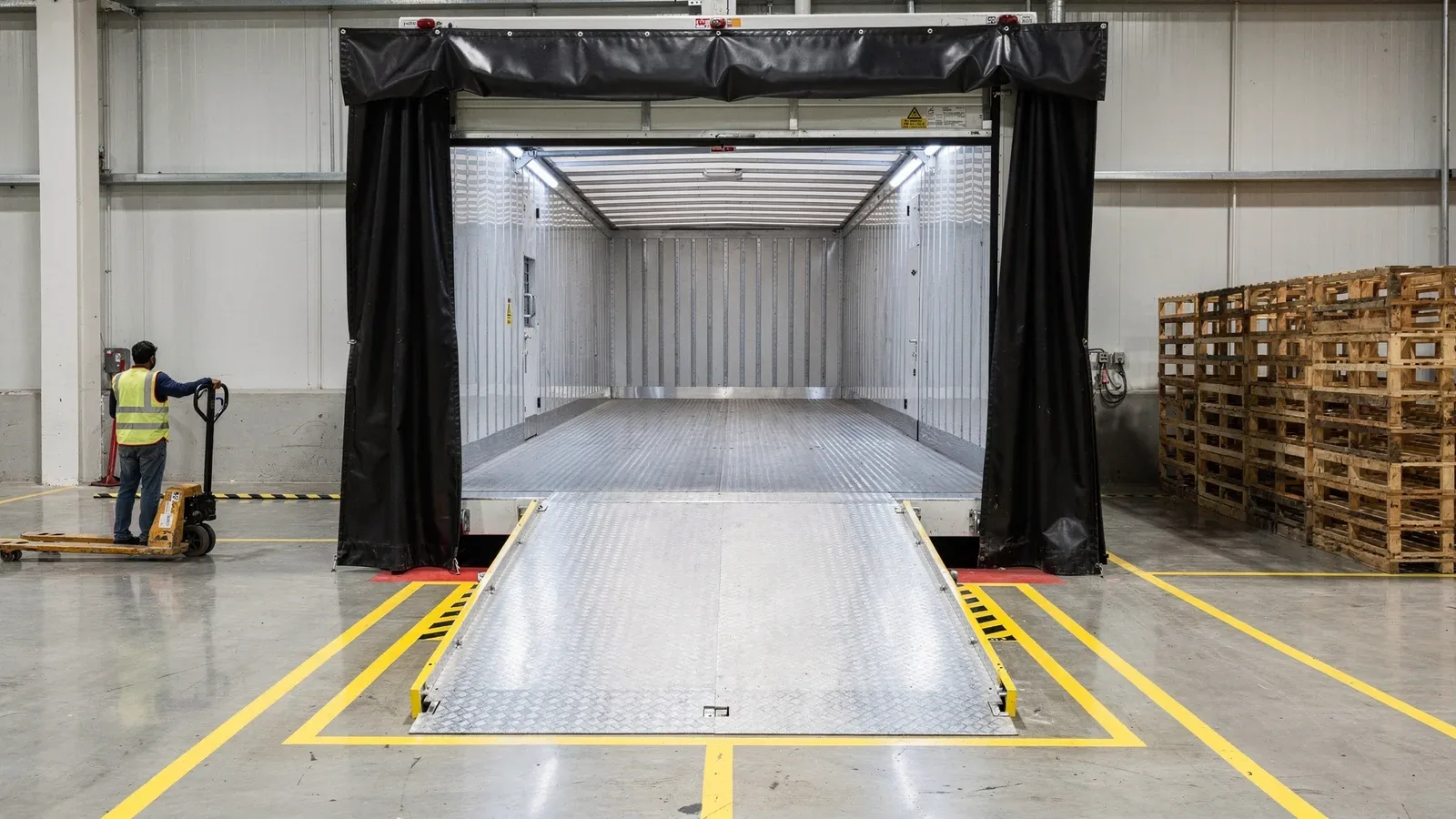 Dock leveler, dock shelter and sectional overhead door at a warehouse loading bay